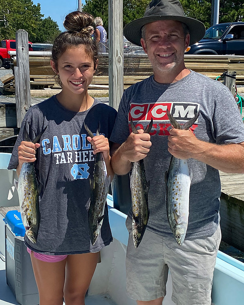 A father and daughter at the dock with their fish